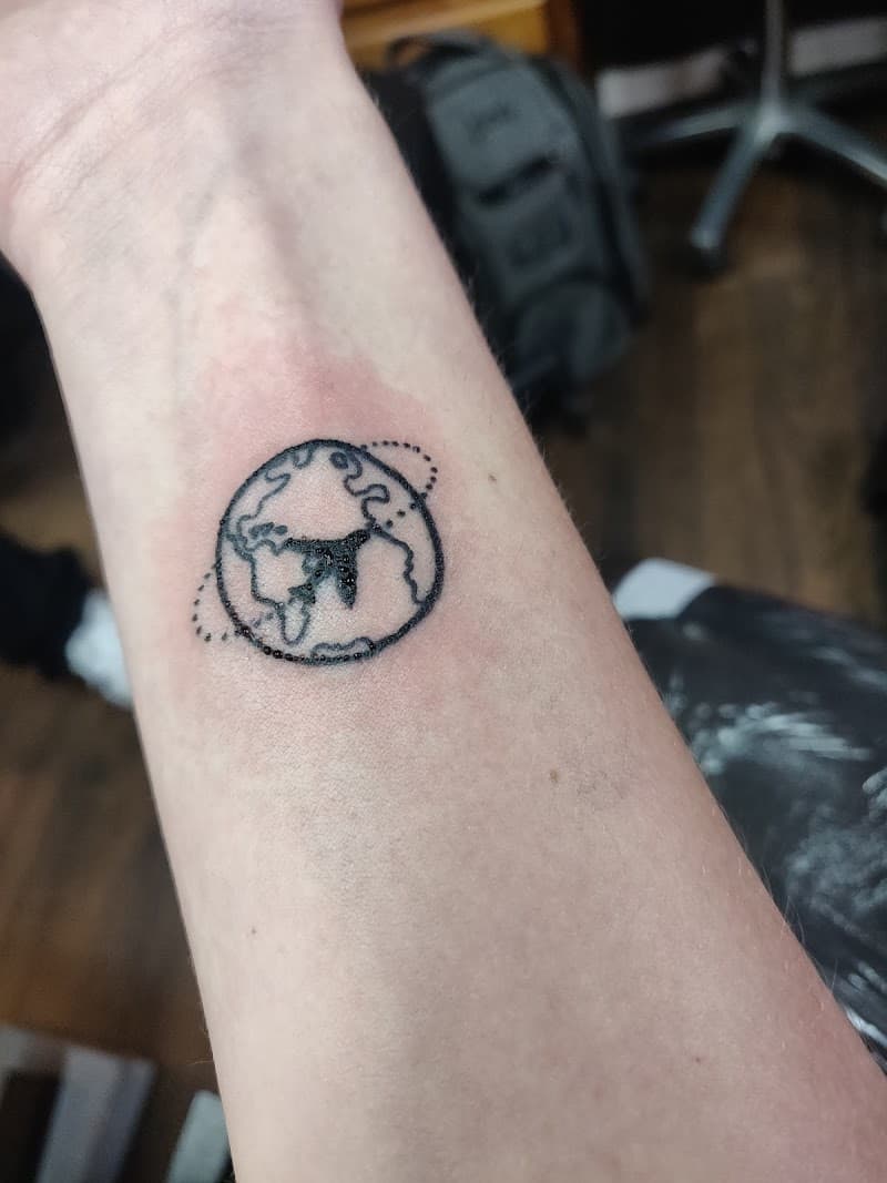 Kleine wereldbol met vliegtuigje op de pols.