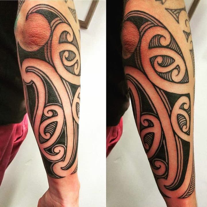 Grote Maori stijl tribal tattoo op onderarm en elleboog.