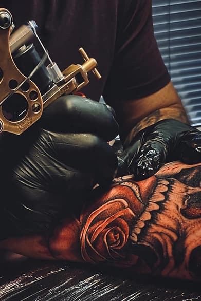 Realistische schedel en roos tattoo in wording op arm.