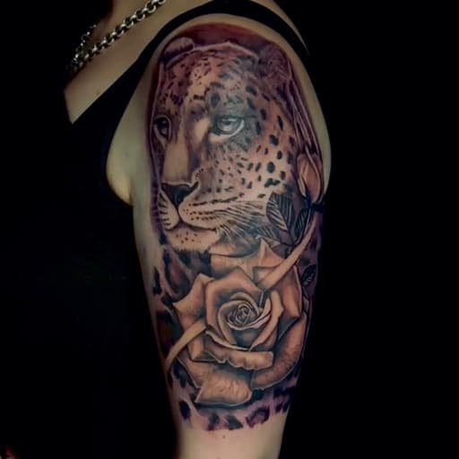 Realistische luipaard en roos op bovenarm.