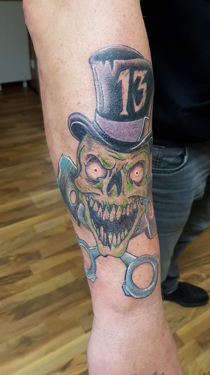 Schedel met hoge hoed en het getal 13, boven een schaar.