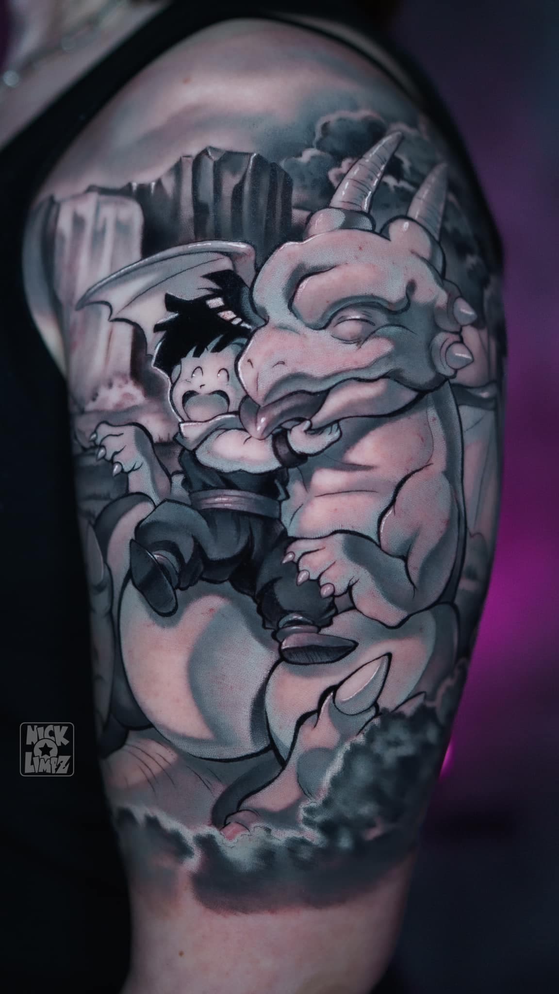 Zwart-wit tattoo van jonge Gohan en Icarus op bovenarm.