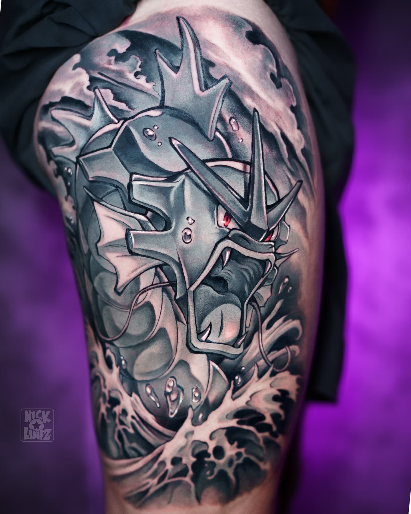 Grote, gedetailleerde Gyarados Pokémon tattoo in zwart-wit met rood oog op bovenbeen.