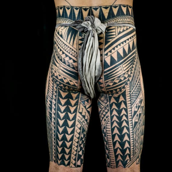 Uitgebreide Polynesische tribal tattoo op billen en bovenbenen.