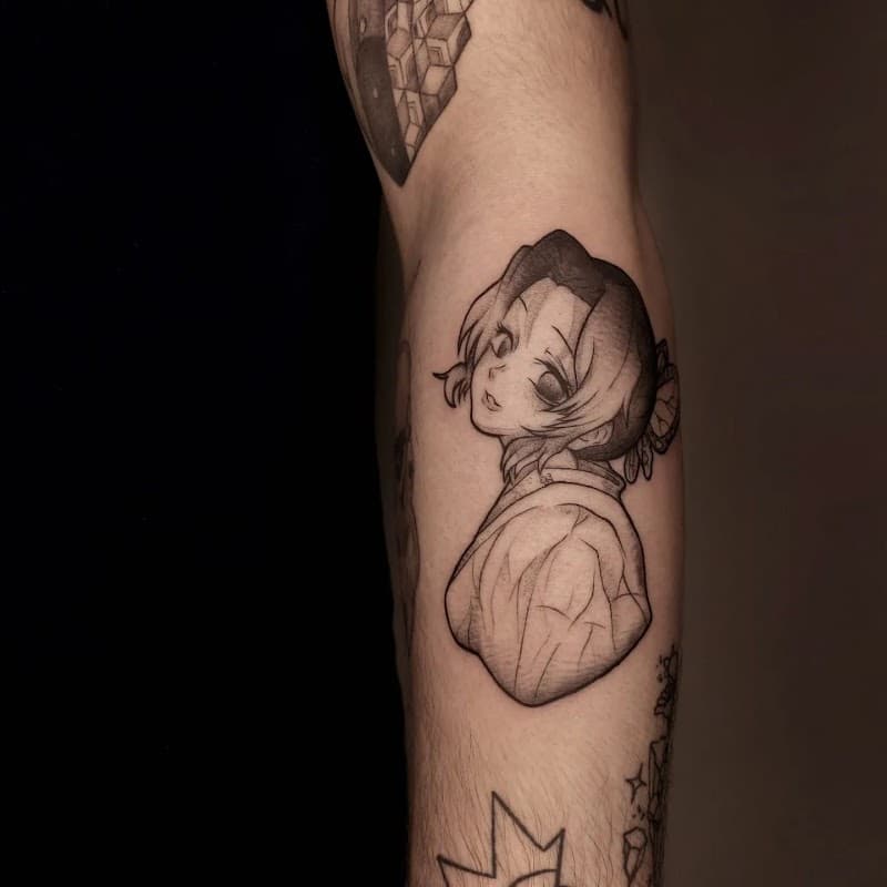 Zwart-wit fineline tattoo van Shinobu Kocho uit Demon Slayer op de bovenarm.