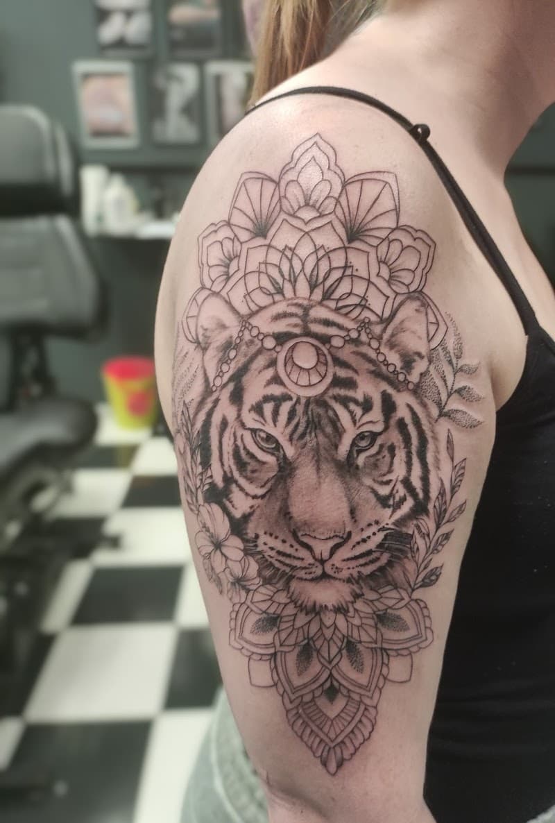 Zwart-wit tijgerkop met mandala en bloemen op bovenarm.