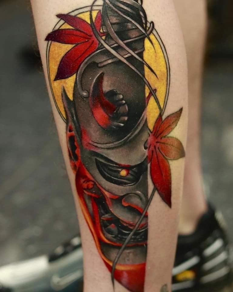 Neo-traditional Hannya masker met mes en herfstbladeren op onderbeen.