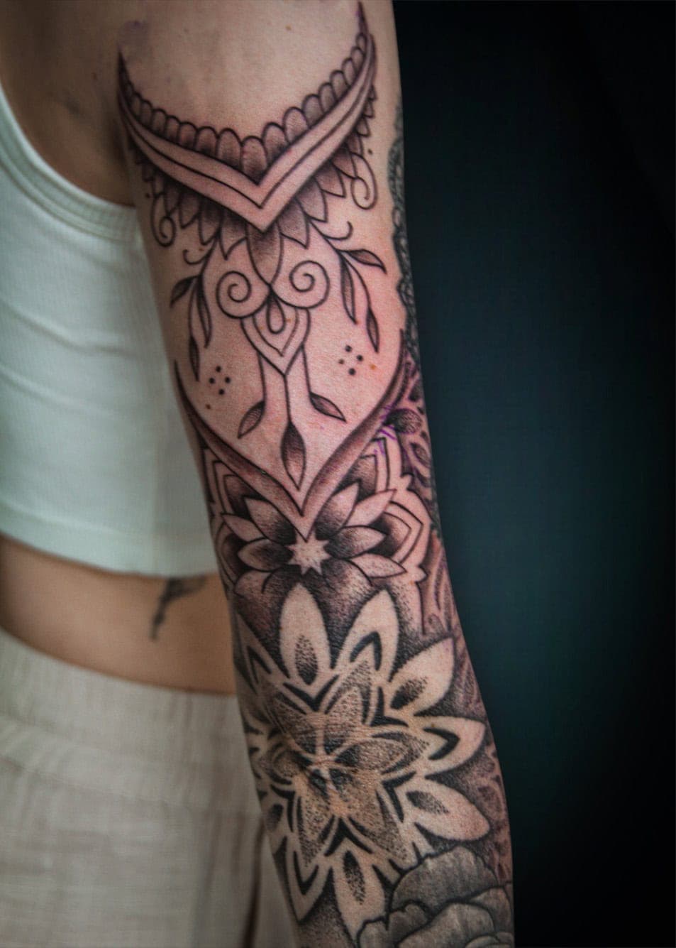 Gedetailleerde blackwork mandala en ornamentele tattoo op de arm.