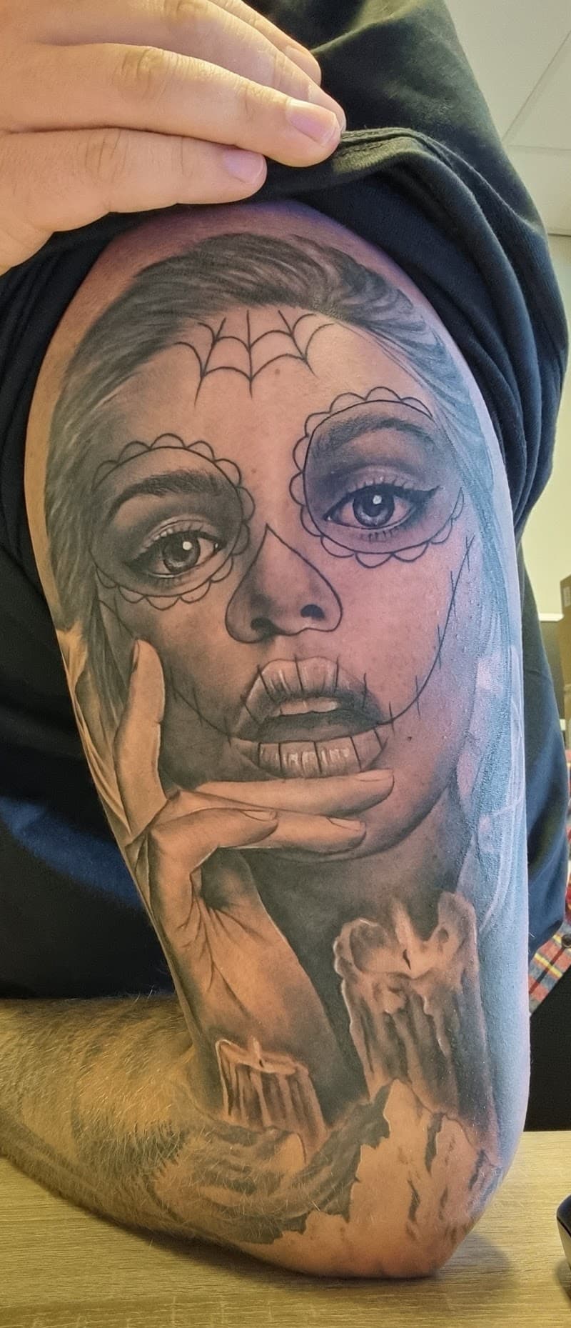 Black & grey tattoo van een vrouw met Day of the Dead make-up, hand en kaarsen.