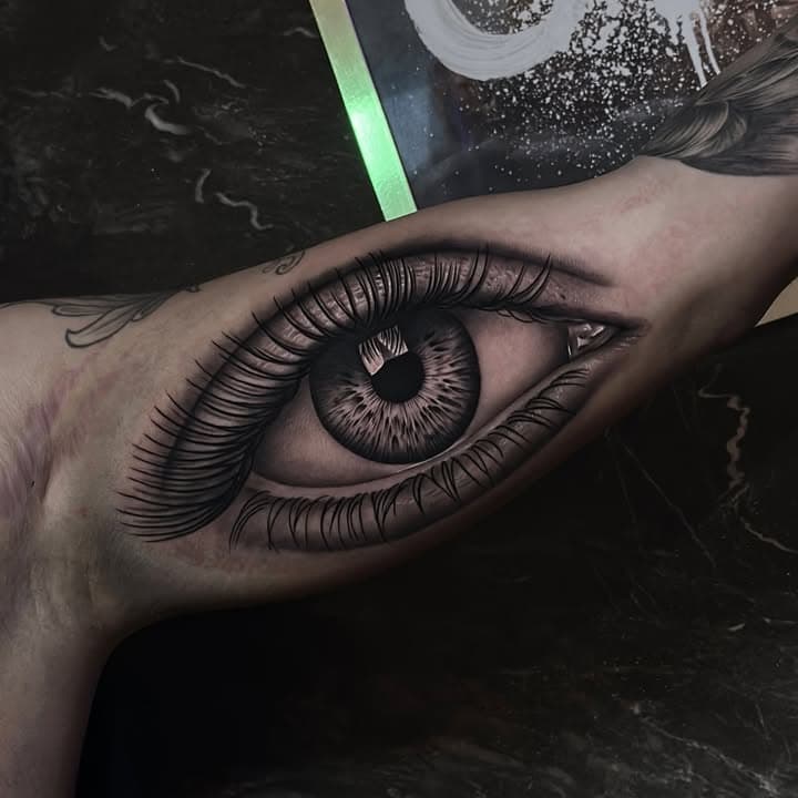 Realistisch oog op de binnenkant van de bovenarm.