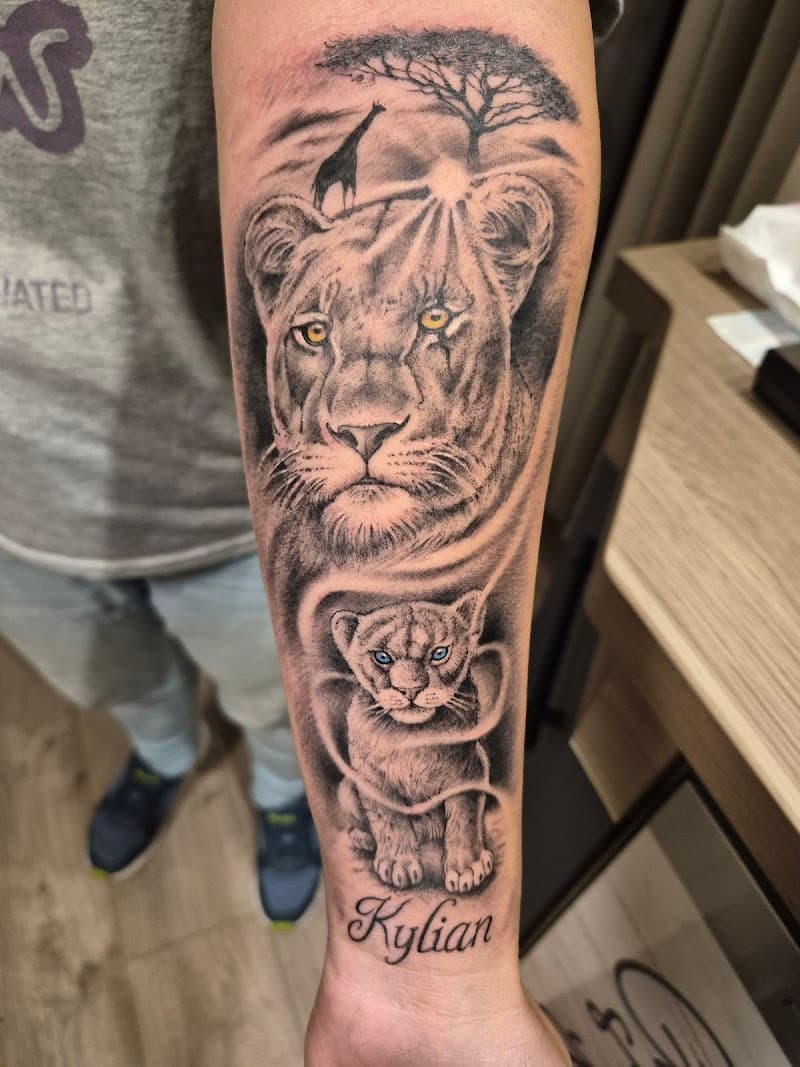 Realistische leeuwin en welp met naam Kylian op onderarm.