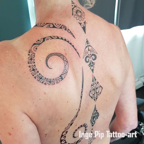 Grote Polynesische stijl rugtattoo met spiraal en ruggengraat patronen.