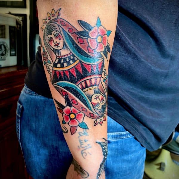 Traditionele Queen of Hearts speelkaart tattoo op de achterkant van de arm.