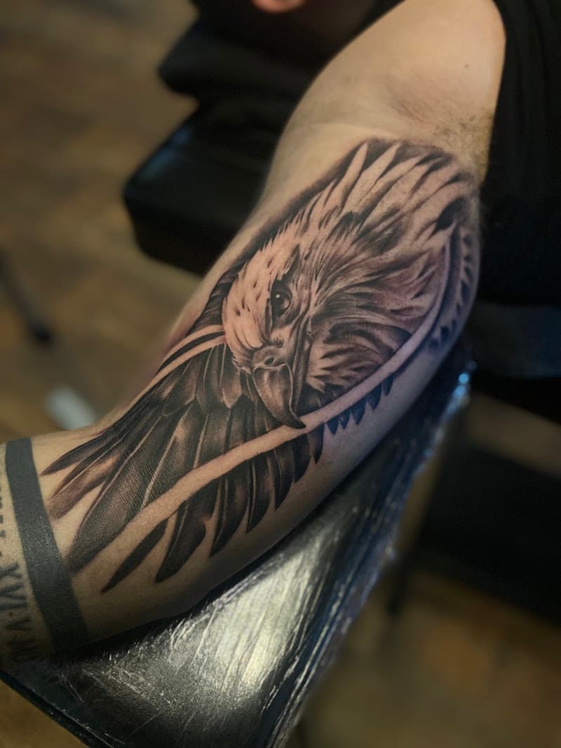 Realistische adelaarskop met vleugel op bovenarm.