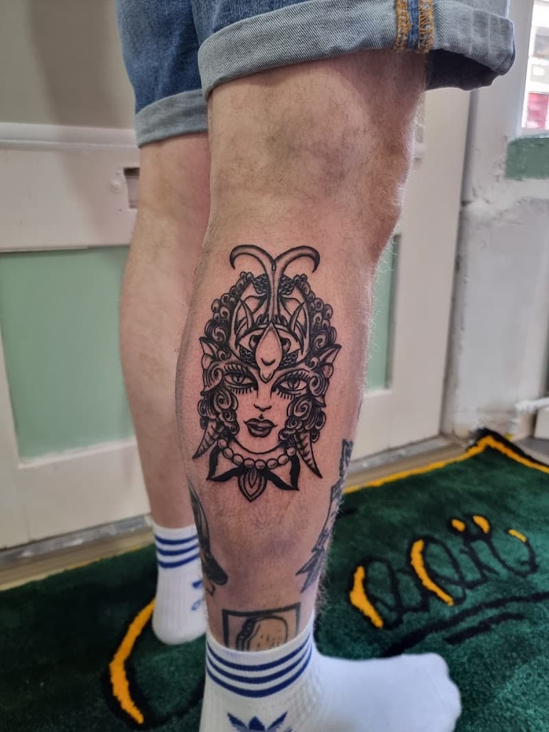 Zwart-wit traditionele tattoo van een vrouwenhoofd met een kever als hoofdtooi.