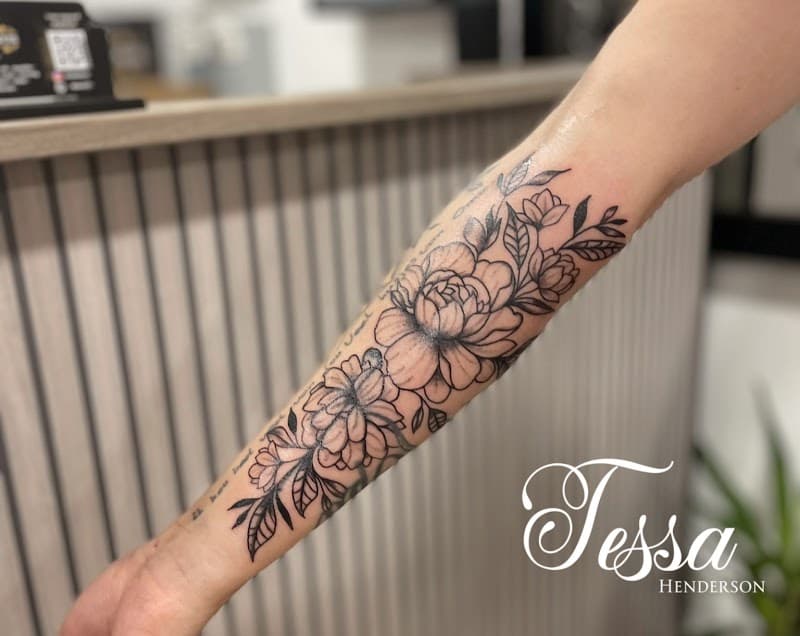 Grote fineline bloemen tattoo op onderarm met bladeren en dotwork.