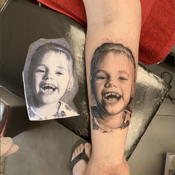 Realistisch portret van een lachend kind op de onderarm.