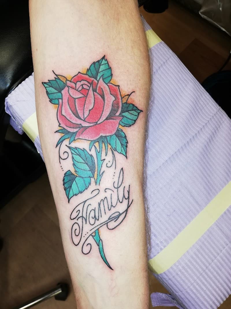 Traditionele roos met 'Family' tekst op onderarm.