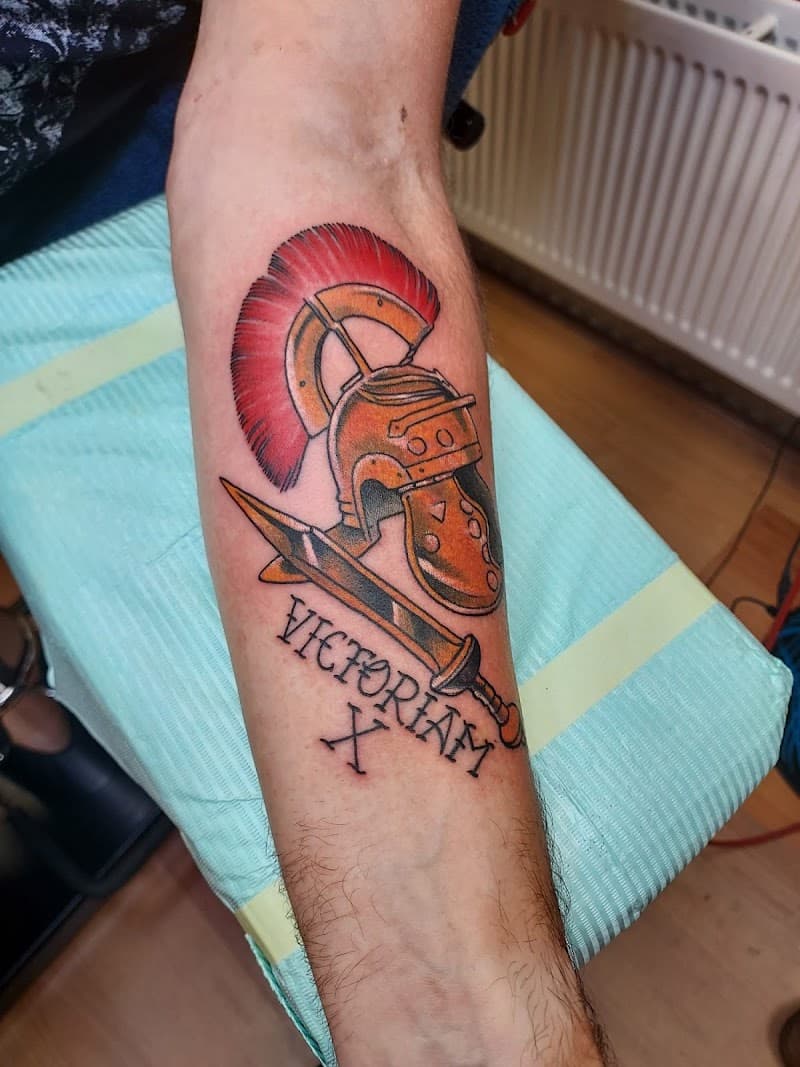 Neo-traditionele Romeinse helm, zwaard en 'VICTORIAM X' tekst op onderarm.
