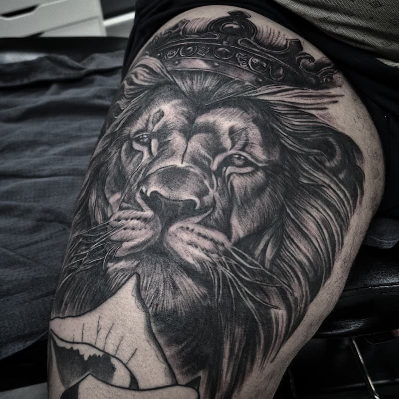 Realistische leeuw met kroon op bovenbeen.