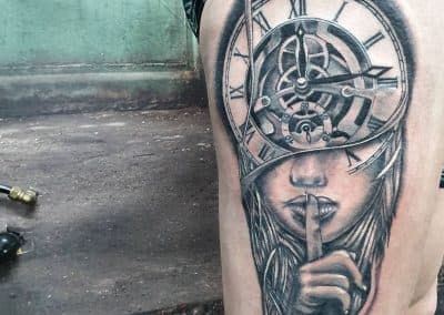 Realistische tattoo van een vrouw met een klok als hoofd, vinger voor de mond.