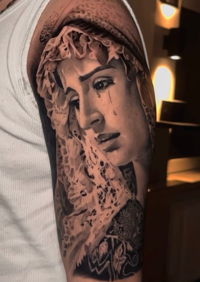 Realistisch portret van huilende Maria met kanten sluier op bovenarm.