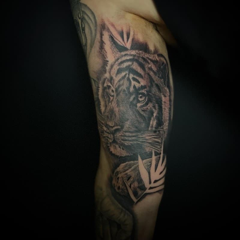 Realistische tijgerkop in zwart-wit op de bovenarm.