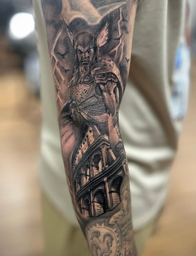 Realistische zwart-wit tattoo van een krijger en het Colosseum op de bovenarm.