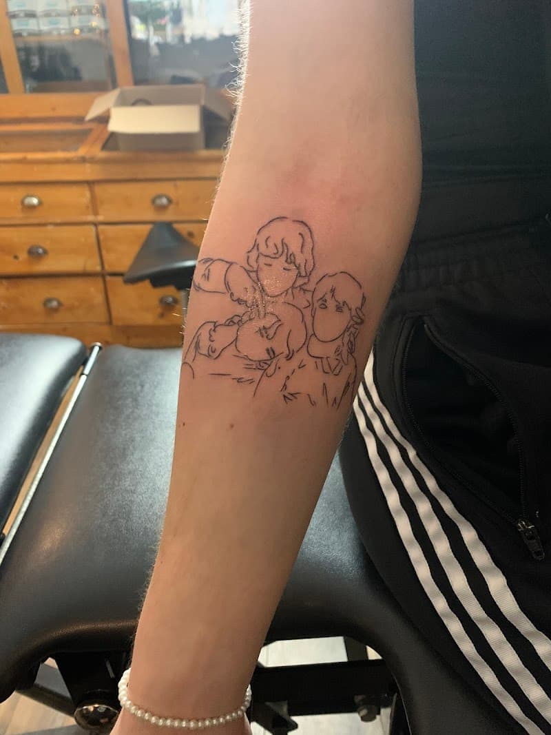 Fineline tattoo van drie figuren in een omhelzing op de onderarm.