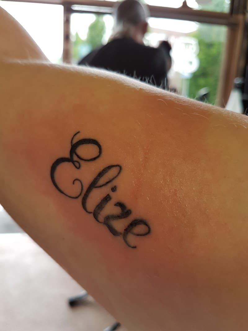 Sierlijke naam tattoo 'Elize' op de onderarm.