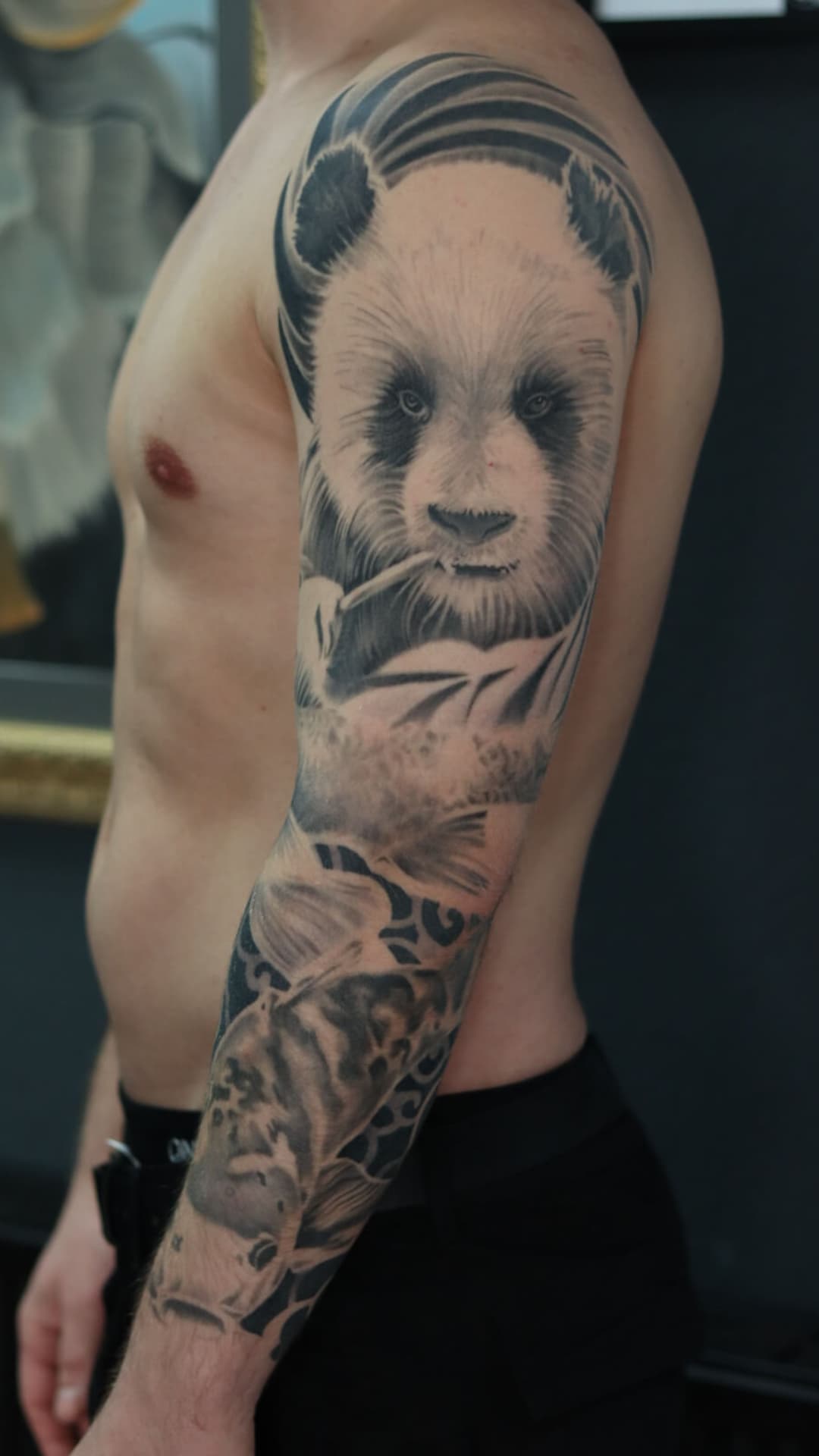 Realistische panda en koi vis sleeve in zwart-wit op de arm.