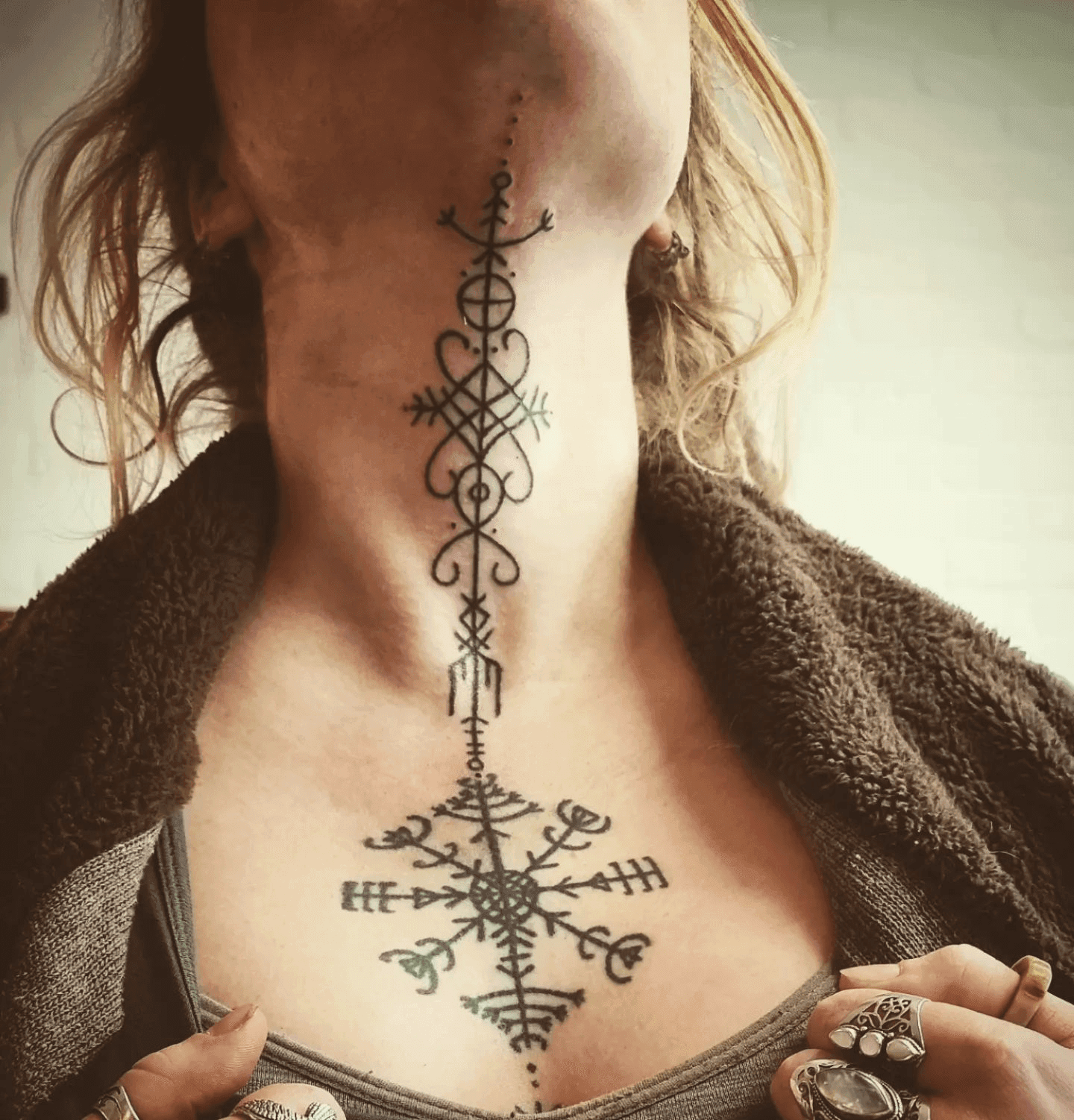 Zwart-wit Noorse runen en symbolen op nek en borst.