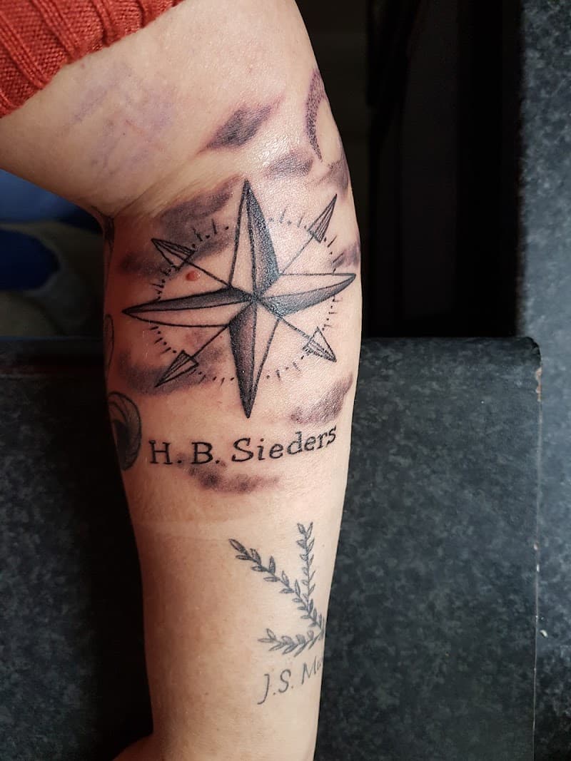 Kompasroos met naam H.B. Sieders en takje op onderarm.