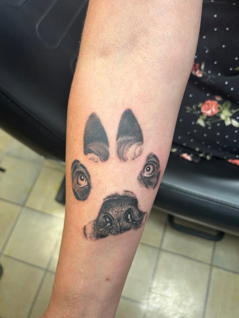 Realistische hondenpoot met ogen en neus erin verwerkt op onderarm.