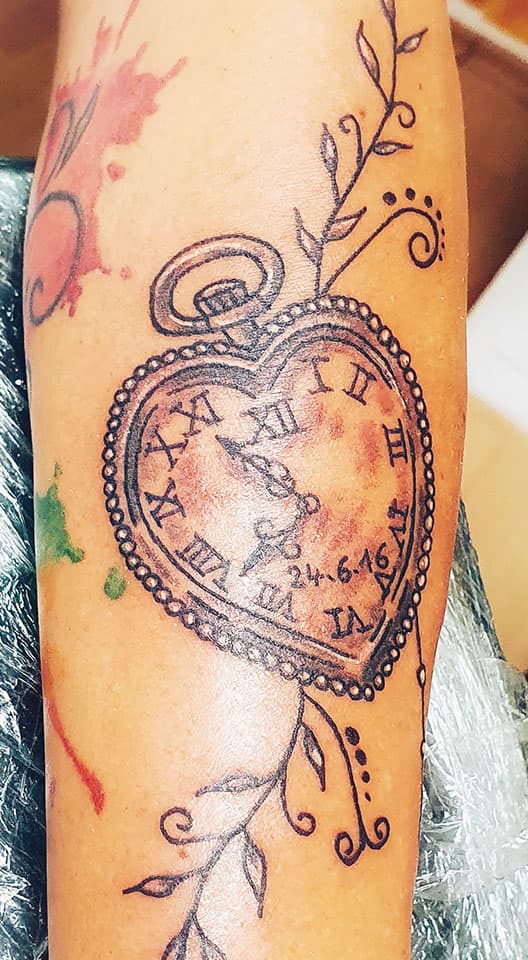 Hartvormig zakhorloge met datum en ranken op onderbeen.