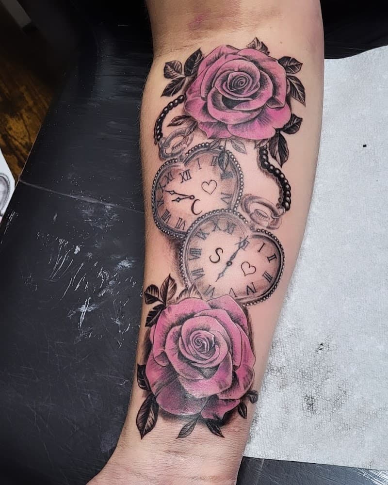 Twee roze rozen en twee hartvormige zakhorloges op een onderarm.
