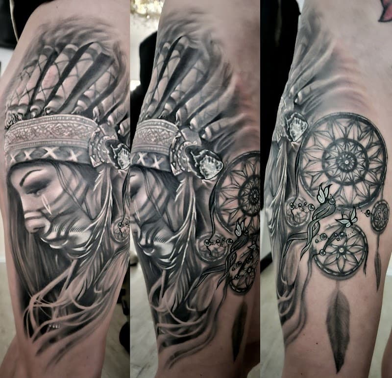 Realistische tattoo van inheemse vrouw met hoofdtooi en dromenvanger op bovenbeen.