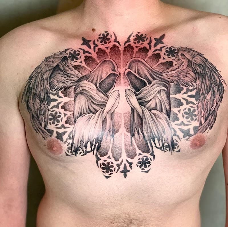 Twee biddende figuren met vleugels voor een gotisch raam op de borst.