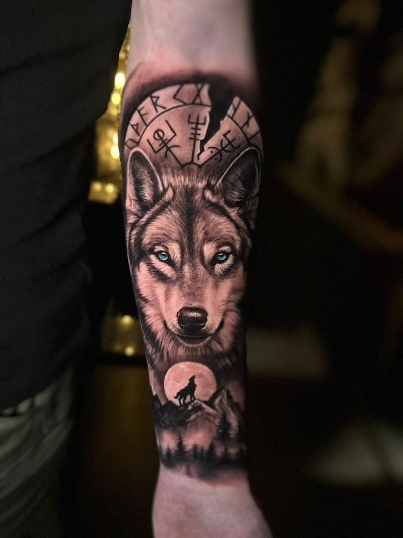 Realistische wolf met blauwe ogen, runen en maanlandschap op onderarm.
