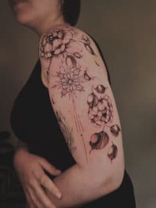 Fineline bloemen en mandala op bovenarm.
