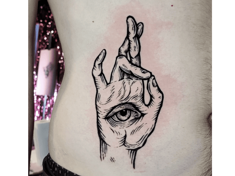 Illustratieve hand met oog en gekruiste vingers op de ribben.