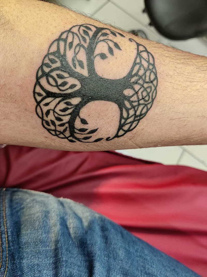 Zwart-wit Keltische levensboom tattoo op onderarm.
