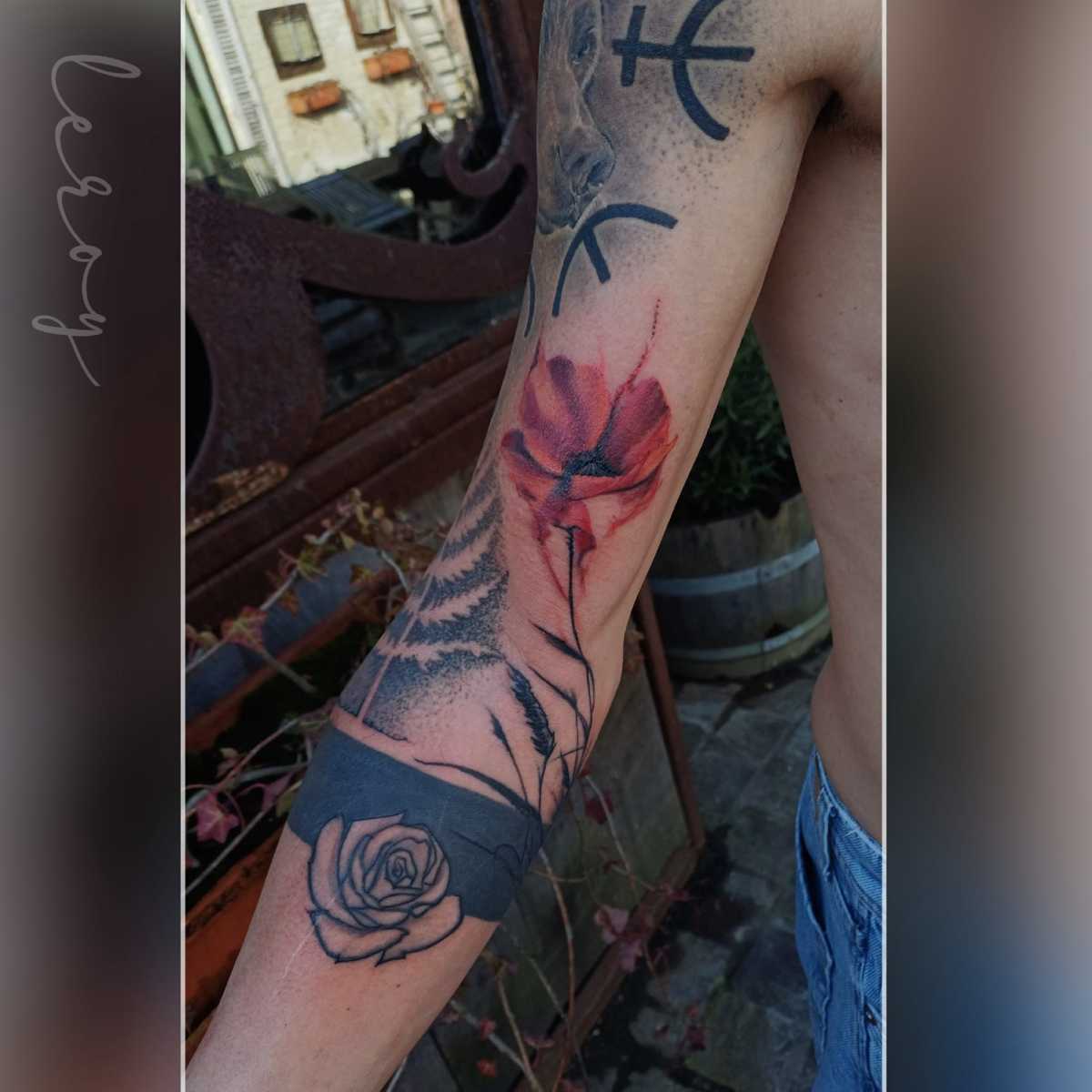 Aquarel klaproos en fineline roos op onderarm.