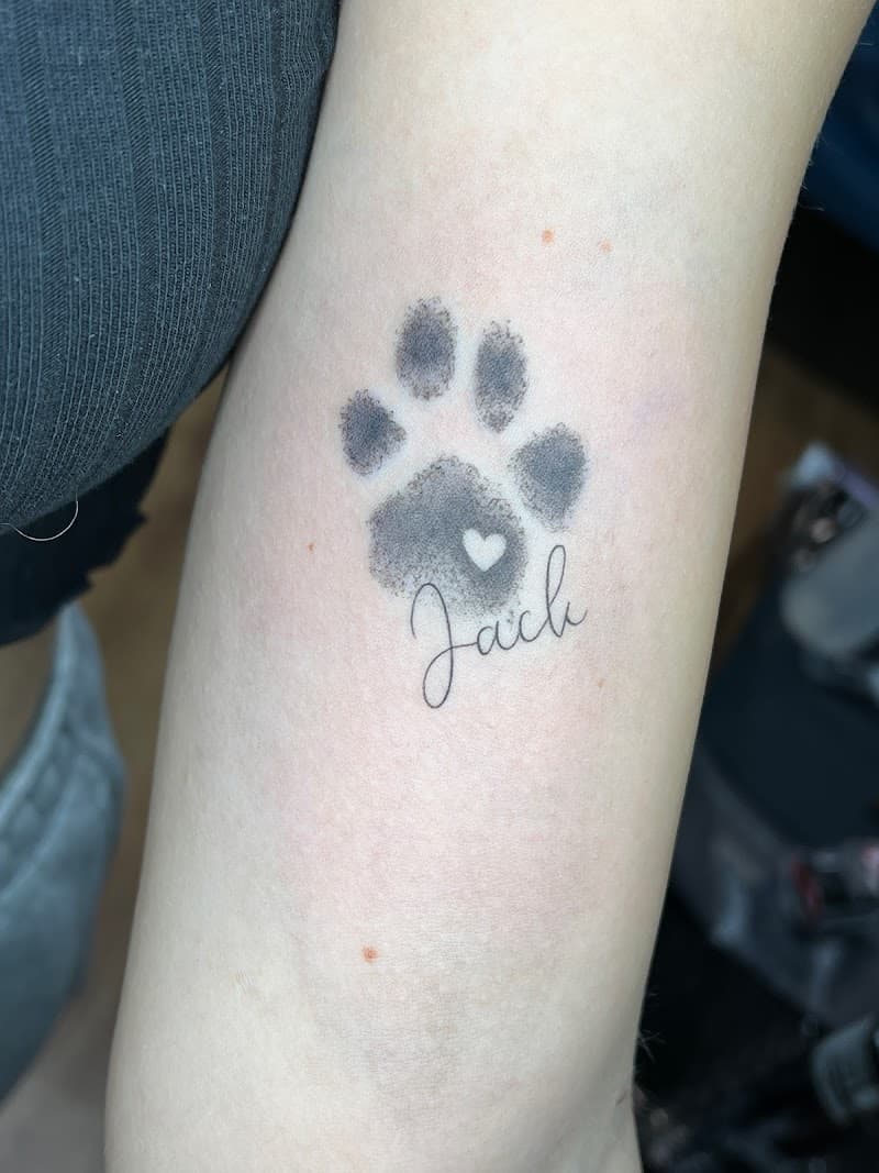 Hondenpootafdruk met hartje en naam 'Jack' op onderarm.