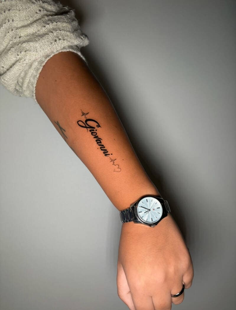 "Giovanni" naam met hartslag en hartje op onderarm.