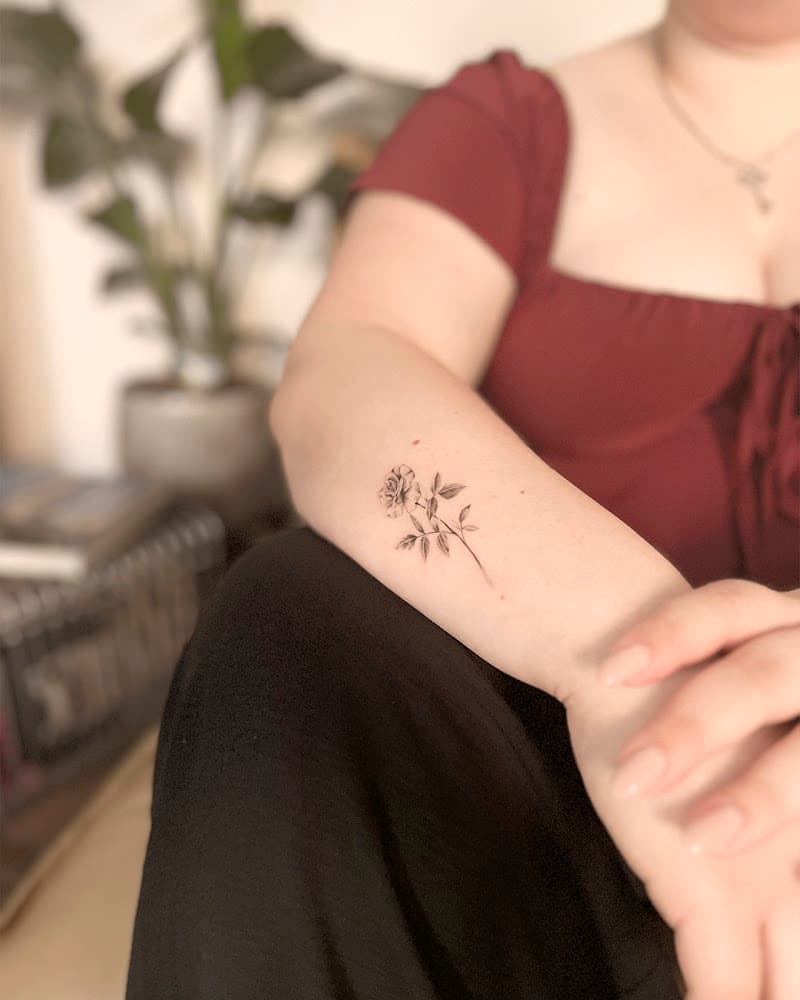 Fijne lijnwerk roos tattoo op de onderarm.