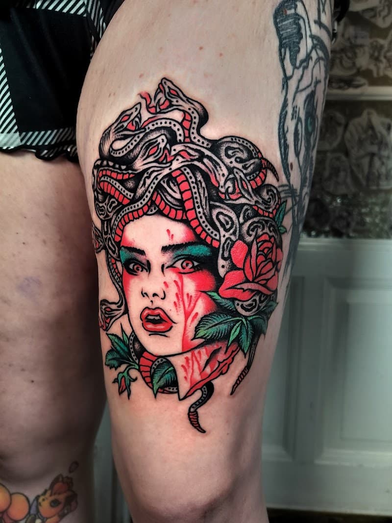 Neo-traditional Medusa met slangenhaar en roos op bovenbeen.