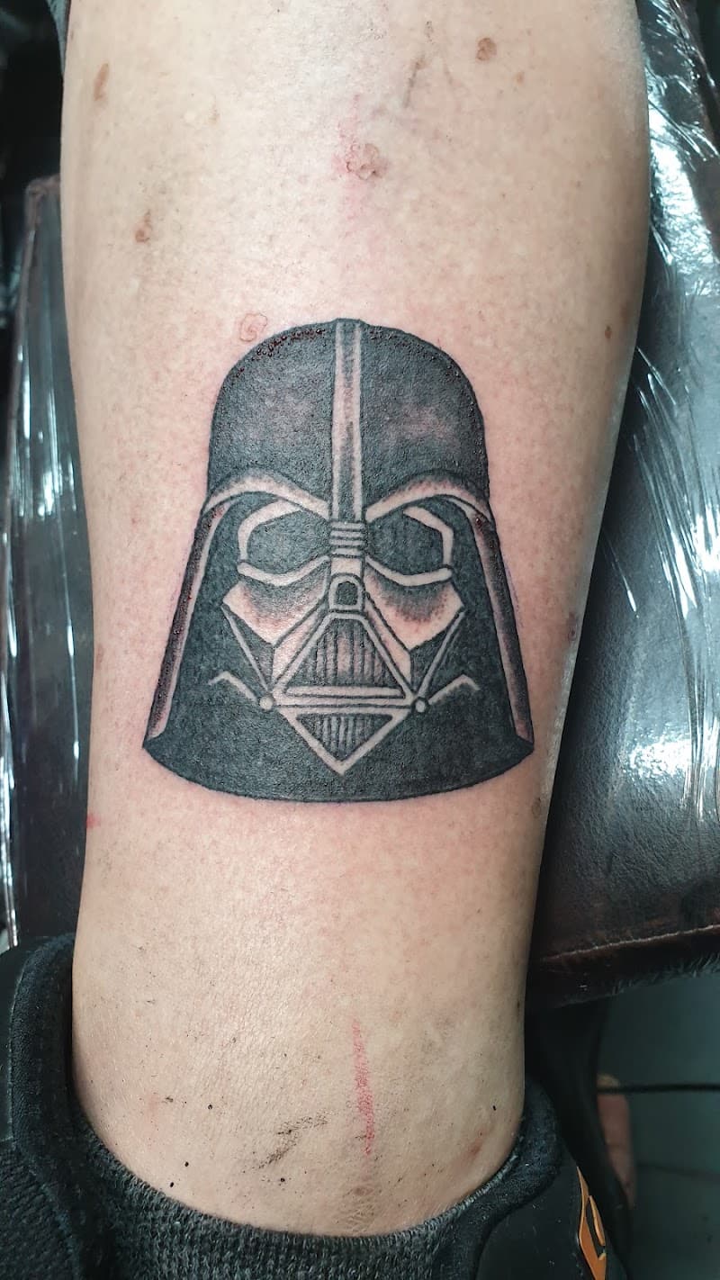 Zwart-wit Darth Vader helm tattoo op het onderbeen.