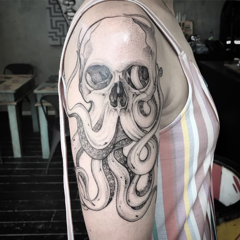 Schedel met inktvis tentakels op bovenarm.