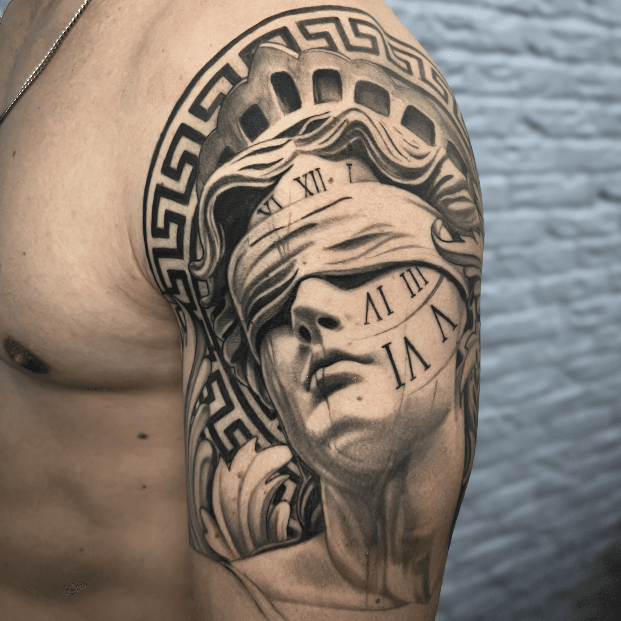 Realistische Vrouwe Justitia met blinddoek en klok op bovenarm.